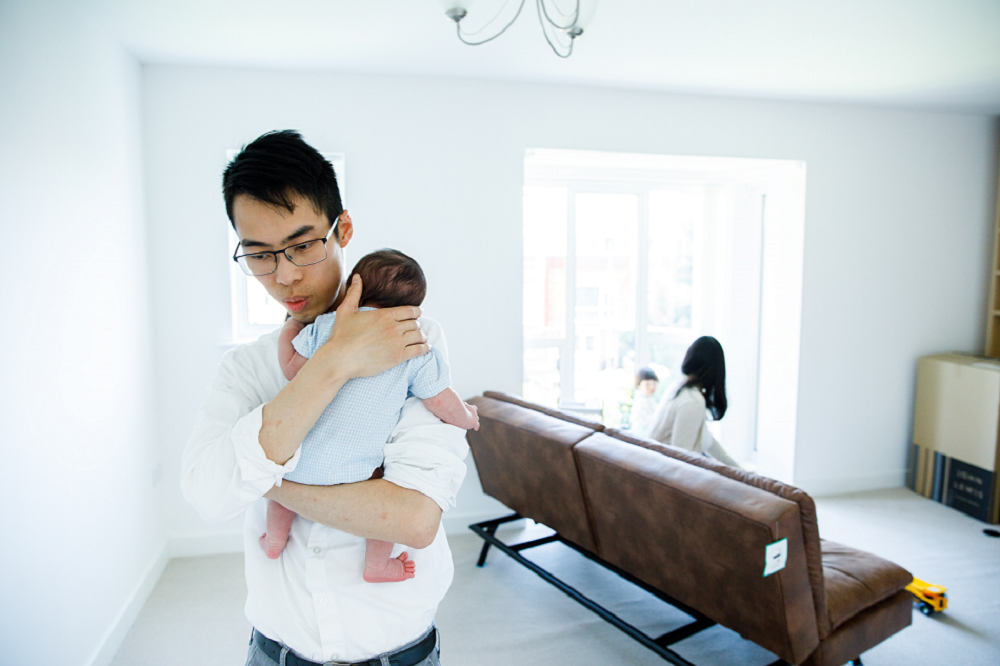 Dad holding and comforting newborn baby on his shoulder