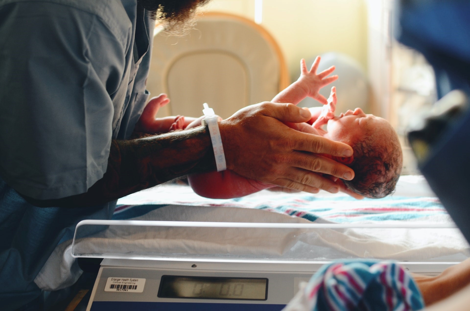 Newborn baby held by medical staff