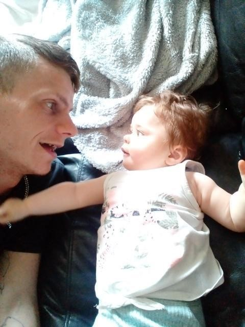 Dad and daughter lying down smiling at each other